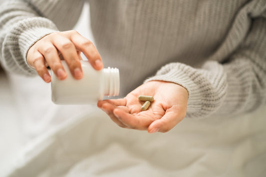 Woman-pouring-beef-organ-supplement-capsules-into-the-palm-of-her-hand.