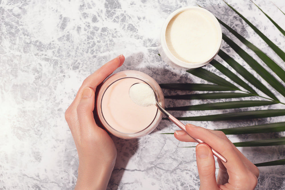 Woman-scooping-collagen-powder-out-of-jar.