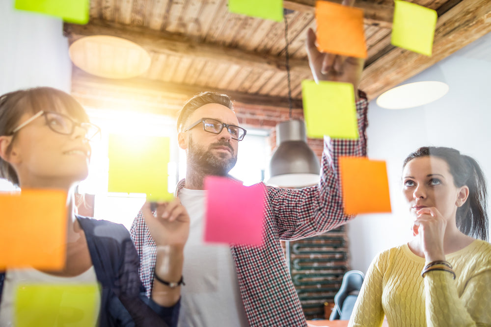 Business-people-in-a-meeting-brainstorming-with-sticky-notes-on-window
